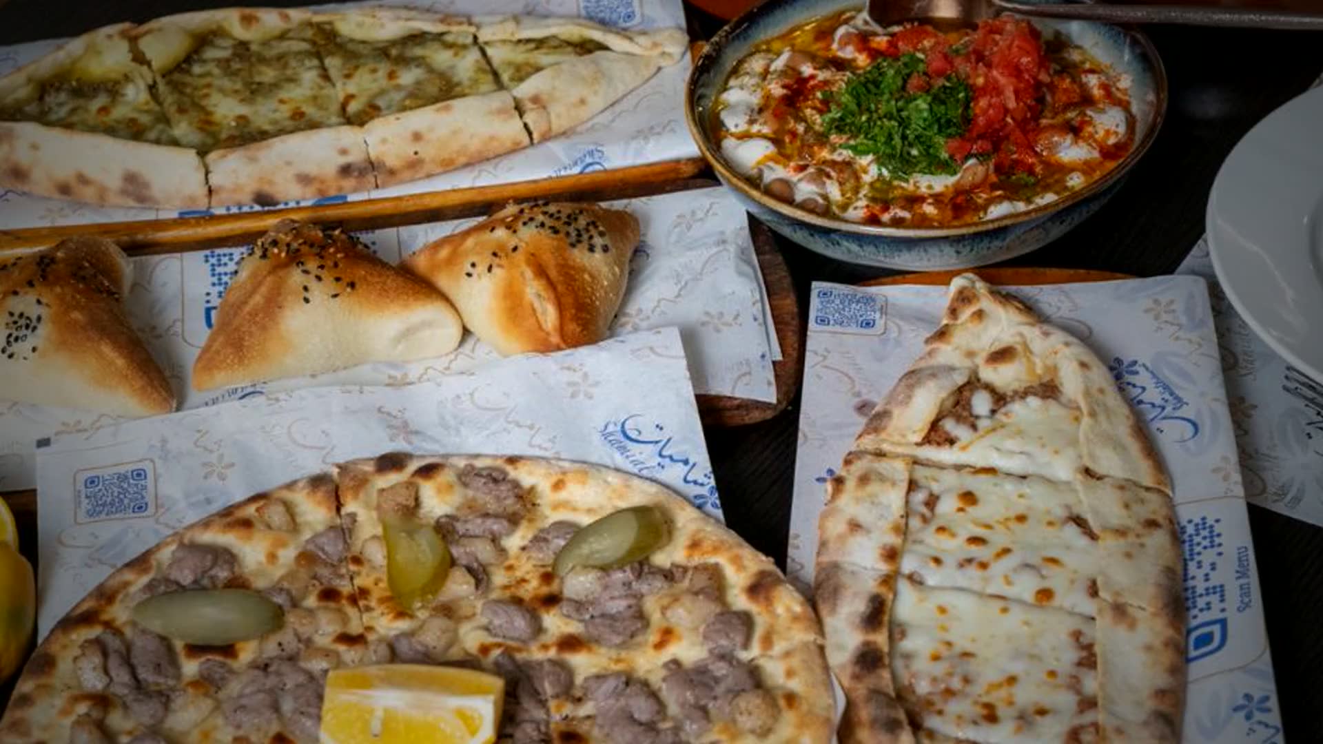 A Shami table at Shamiat — pide, manakish, fatteh and fresh baked breads